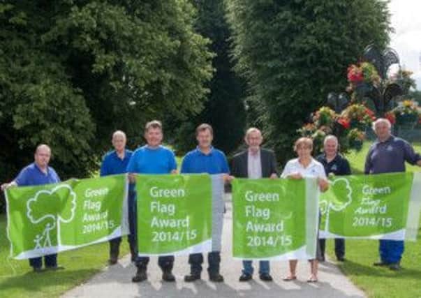 Chair of Environmental Services Committee, Councillor Noel McGeown joins Parks Development Officer, Leanne McShane in presenting the parks staff with the four Green Flag Awards  for Lurgan Park, Edenvilla Park, Bann Boulevard and Tannaghmore Animal Farm and Gardens.