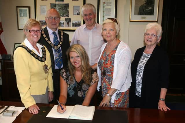 Katherine Duncan signs the visitors book at a recent reception with the Mayor of Ballymena, Cllr. Audrey Wales, prior to leaving for Sao Paulo in Brazil in September to work with children who have been rescued from child sex trafficking. Katherine is pictured with her parents Trevor and Karen Duncan, and grand mother Jean Barr. INBT34-212AC