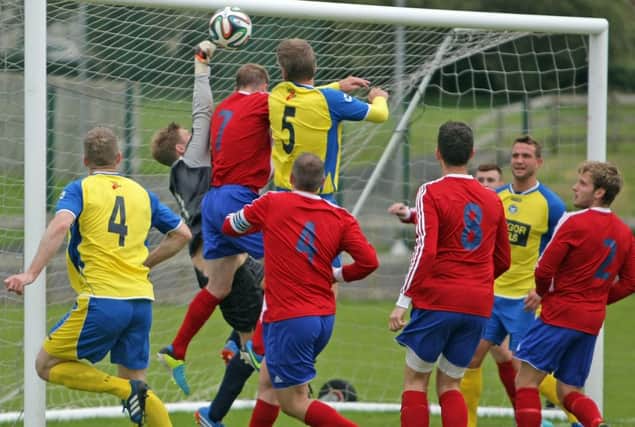 MAKING A FIST OF IT. Glebe Rangers keeper, Brian Kane punches the ball clear following a corner despite the close attention of Bangor's Nixon on Saturday.INBM34-14 092SC.