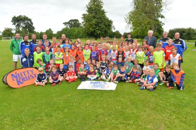 Councillor Alan Carlisle, Vice-Chair of the Council's Leisure Services Committee with the young participants and the IFA coaching staff at the IFA Summer Soccer School held in Moira Demesne recently.