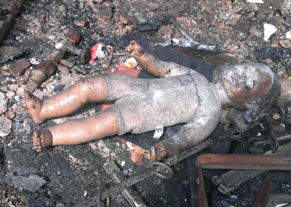 A little girl's doll lies in the charred remains of a fire which almost claimed the lives of an entire family