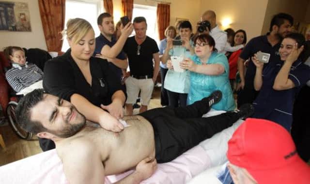 Staff member Carlos Gomes gets his chest waxed for charity at Lisburn Intermediate Care Centre's party.  US1434-536cd  Picture: Cliff Donaldson