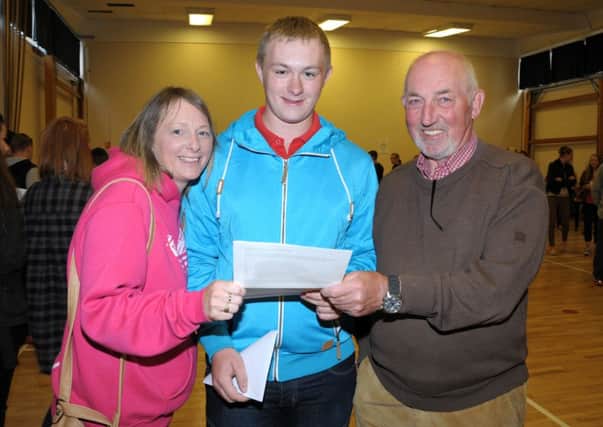 Downshire School student Robert Arbuthnot with his mum, Jennifer, and grandfather, Ian Johnston.  Robert earned GCSE grades of an A*, 3Bs and 4Cs.  INCT 36-209-AM