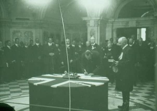 The Unionist leader Sir Edward Carson signs the Ulster Covenant at Belfast City Hall in 1912