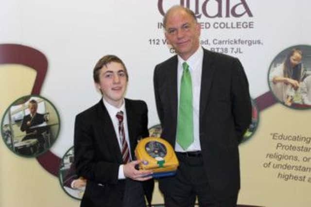Pupil William Telford and Ulidia Integrated College principal Eugene Martin with the new defibrilllator. INCT 36-701-CON