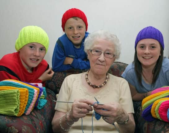 T'HATS' OUR GRAN.  Pictured is 81-year-old Elizabeth Wallace with her proud grandchildren Callum, Cameron and Ellie, who are wearing just some of the hundreds of hats Elizabeth knits for Blythswood Charity Shop and other worthy causes.INBM36-14 002SC.