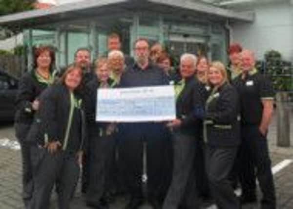 Staff at the Marks and Spencer store in Newtownabbey hand over a cheque for £25,365 to the Huntingtons Disease Association Northern Ireland (HDANI). INNT 46-607-CON