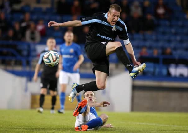 Ballymena United skipper Allan Jenkins hurdles a challenge from Glenavon's Ciaran Martyn during Friday night's Danske Bank Premiership game at Mourneview Park. Picture: Press Eye.