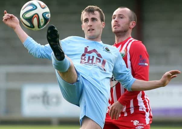 Institute's Stephen Curry shields the ball from Warrenpoint Town's Stephen Hughes, during Saturday's match at Drumahoe. Picture by Lorcan Doherty/Presseye.com