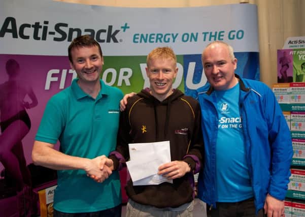 Cormac McGarry from Ballycastle receives his prize following his victory in the mens sprint race category at the Lough Neagh Tri-athlon.