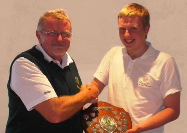 The losing Juveniles Captain presents the Shield to Club Captain Peter Cairns at Lisburn GC.