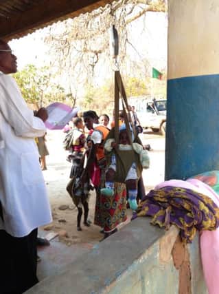 Dr Alfred Mwiinga, weighs one of the babies brought to the health clinic in Luili village, central Zambia.