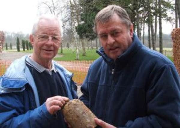 Fraser Agnew (right) showing Teddy Colligan, Curator of the Ulster Tower at Thiepval, part of a gas shell found when excavating trenches in Thiepval Wood. INNT 37-506CON