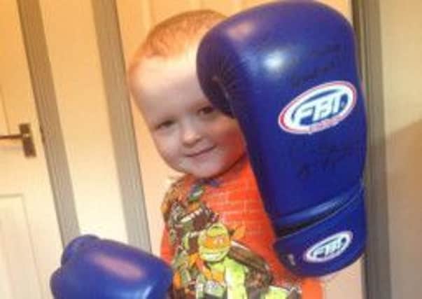 Brave Ballyclare boy Ross Patterson shows off his Carl Frampton-autographed boxing gloves.