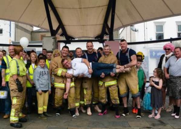 Mayor of Larne, Martin Wilson gets a 'Firemans Lift' after walking a mile in his heels at the PIPS Larne Fundraiser on Saturday.  INLT 37-702-con