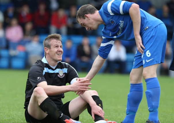 A picture which encapsulates Ballymena United's defeat at Ballinamallard on Saturday as Mallards player David Kee helps lift grounded Unuited skipper Allan Jenkins. Picture: Press Eye.