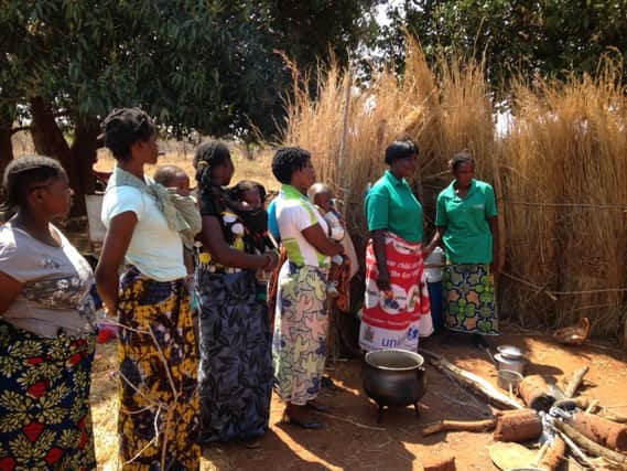 Agnita Munyama, second right, one of the community health volunteers in the Lungo village demonstrating cooking techniques to local women.