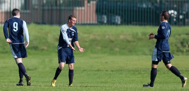 Steadfast's Steven McGaughey (centre) is congratulated by team mates Philip Redmond (left) and Scott Kennedy (right)after scoring his team's second goal during their Saturday Morning League Division 3 win over Athletico Antrim at Galgorm. INBT 38-177CS
