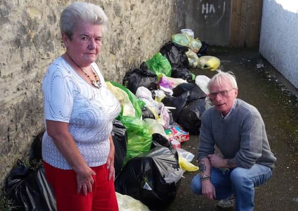 Victoria Gamble and Lloyd Magee inspecting dozens of rubbish bags dumped at Roulston Evenue in Bond's Street.