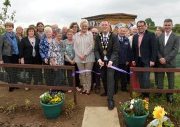 The Mayor Councillor Andrew Ewing cuts the tape to open the Allotment