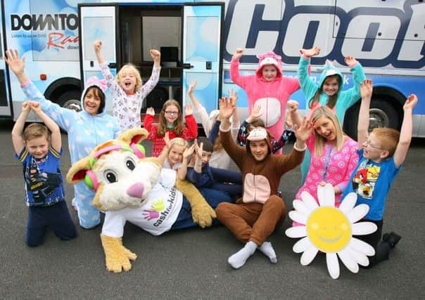 Pupils from Crossroads PS with (L-R) Downtown Radios Kirstie McMurray, Courage the Cash for Kids kitty, Cool FMs Paulo Ross and Cancer Fund for Childrens Rebecca Spiers. They are urging people to sign up to Cash for Kids Funsie in a Onesie to raise money for Cancer Fund for Children.