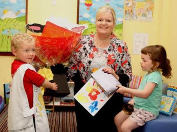 James Donaghy & Ava Conway children at Tiny Steps Creche  present the Mrs Lewsley- Mooney with flowers and a card.
