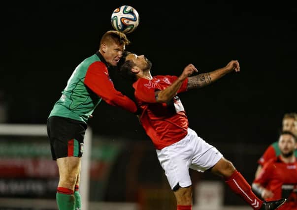 Glentoran's Kym Nelson challenges Larne's Scott Irvine in the air during Tuesday's Toals County Antrim Shield first-round game at The Oval. Photo: Presseye