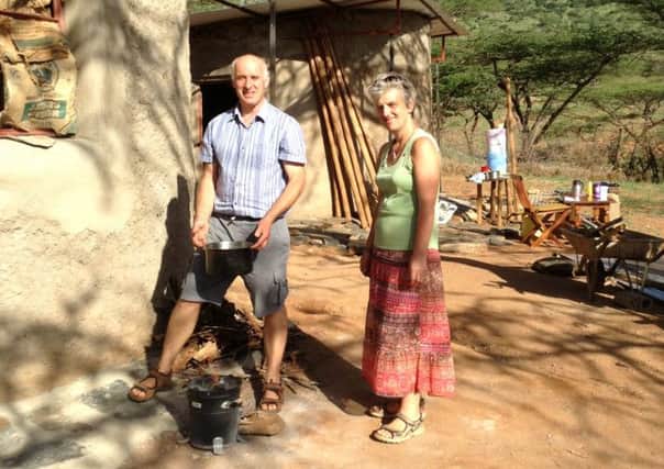 Paul and Elizabeth Davis outside their hand-made home, with their wood cooker or jiko at their feet. The diet was almost vegetarian.