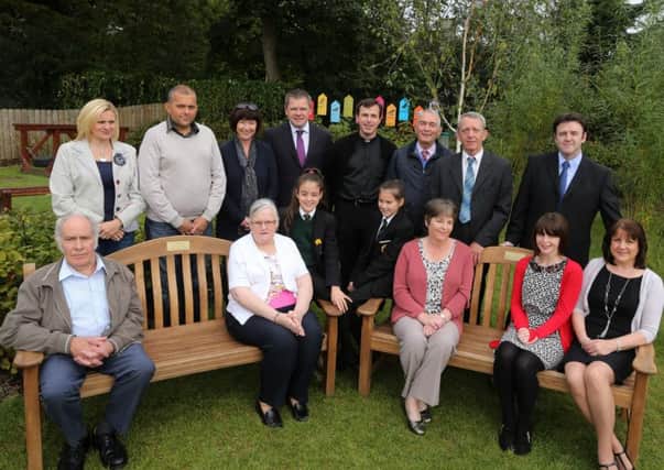 Members of the families of former pupil Caelan Esler and former staff member Stella Arbuthnot are seen here with the garden seats which were unveiled in their memory at last week's opening of the ECO garden at St Brigid's Primary School. Included is school principal Mr Jim Brady and school chaplain Fr Darren Brennan. INBT 40-108JC