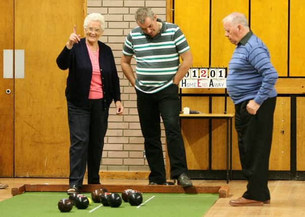 Roberta Wilson of West Church signals a good delivery as looking on are Maine bowlers John Heffron and Brian Kerr. INBT40-204AC