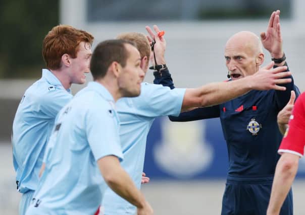 Referee Colin Burns waves away Ballymena United players' protests over the 'penalty that never was' saga in Saturday's game against Cliftonville. Picture: Press Eye.