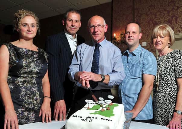 Trevor McKay founder member of the Mid-Ulster Walking Club cuts the cake to officially celebrate the clubs 25th anniversary with the help of Carmel McGuigan (Treasurer),Ken Armstrong (Secretary), George Hamilton (Chairperson) and Joan Shaw (Senior Member).INMM3914-385
