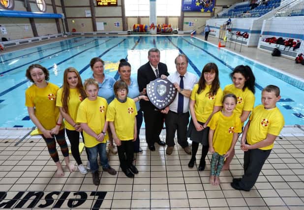 Alderman Paul Porter, Chairman of the Council's Leisure Services Committee is pictured alongside coaching staff and participants of the Life Saving School at Lagan Valley LeisurePlex with the Life Saving Shield given to the facility by the NI Branch of the Royal Life Saving Society for the most Lifesaving Awards taken during the year.