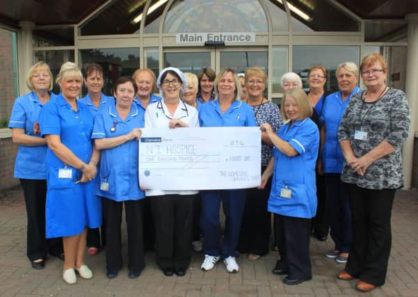 Jacqueline Herald (sixth from left) and friends from Whiteabbey Hospital domestic services have raised £1,000 for NI Hospice.