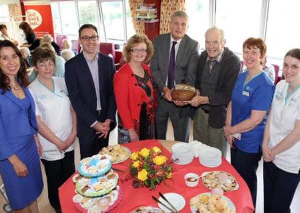 Health Minister Jim Wells called at Lagan Valley Hospital to mark International Older People's Day. Pictured, from left, are Roisin Coulter, planning and performance director; Pat McGeeney, occupational therapist; Dr Roberts, consultant; Dr Kelly, consultant; Jim Wells; Fenton Lyons, patient; Jane Cairns, ward manager; and Michelle McNulty, physiotherapist. US1440-528cd  Picture: Cliff Donaldson