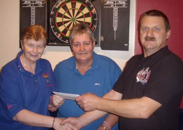Alex Irvine, chairman of the No. 1 Club Larne, presenting £366 to Norma Irvine and Barbara Allen of Larne Ladies Select darts team. The money will help towards the team's expenses for the incoming season. INLT 40-901-CON