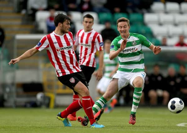 Derry City's Phillip Lowry gets his pass away before Shamrock Rovers midfielder Ronan Finn could challenge.