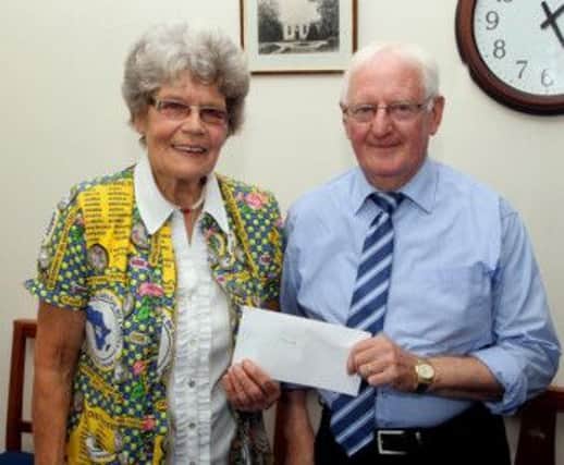 Jim Atkinson presents a cheque to Maud Kells on behalf of the Presbyterian Churches in Moneymore and their friends to finance the construction of a bridge in Africa.