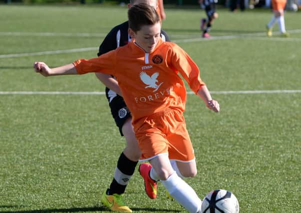 Carrick Colts Under-13s defender Nathan Swain in action against St Oliver Plunkett.