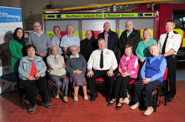 Tim Richmond Cookstown Fire Station Commander surrounded by Good Morning project members from Cookstown, Magherafelt and Dungannon during Tuesday afternoon's official launch of the Good Morning Mid Ulster & Good Morning Neighbour Agreement to Protect Those Most at Risk from Fire as part of Fire Safety Week 2014.INMM4114-405