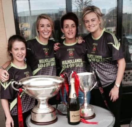 Annaclone's Down girls Mairead Grant, Eliza Downey, Aileen Pyers and Grainne Kelly pose proudly with the All Ireland IFC trophy along with the Junior Camogie cup also won by the Mourne County.