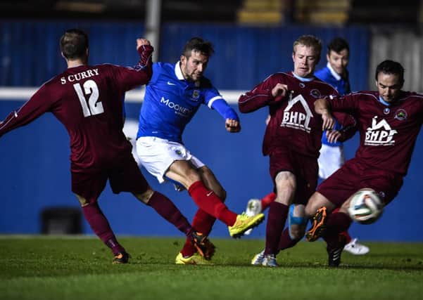 Linfield's Andy Waterworth gets his shot away despite being closed down by Institute trio Stephen Curry, Graham Crown and John Curran, during Monday nights game, at Windsor Park. Picture by Russell Pritchard/Presseye