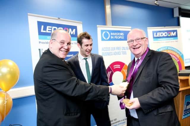 Councillor Billy Ashe, chairman of the new Mid and East Antrim Council,  tries on Mallusk Paralympic  athlete Michael McKillops gold medals for size to the amusement of fellow Councillor Paul Reid at an event to mark LEDCOM achieving Investors in People Gold status. INCT 42-703-CON