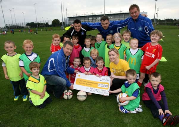 Robert Adams of Northend Youth presents a cheque for £1200 to Kirsty McAllister of the NI Cancer Fund for Children. The Money was raised from the coaches and parents who took part in the Belfast Marathon. Included are team members and coaches Jonny Sayers, David Hendron and Brian O'Hara. INBT40-201AC