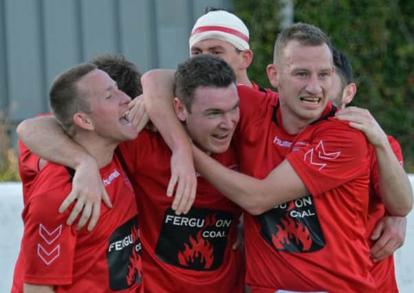 Gerald Gillan is mobbed by his team-mates after he scored Larnes opener against Dergview. Photo: Phillip Byrne