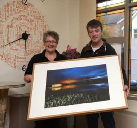 Photographer John O'Neill presents his award winning photograph to Carol Dooey from The Hub.