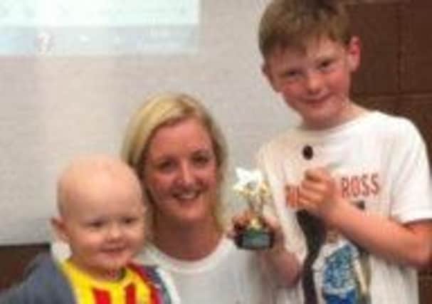 Claire Patterson with sons Ross and Jack pictured receiving their trophies at the Run for Ross event. INNT-43-711CON