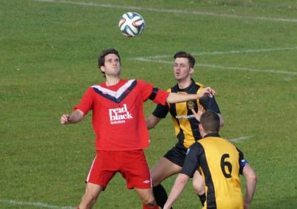 Ballyclare striker Chris Trussell is closely watched by Carrick's Daniel Kelly.