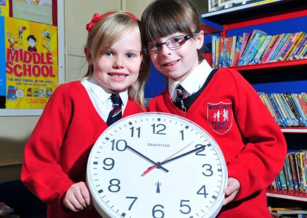 Primary 2 pupils from Moneymore Primary School Bobbi and Gail pictured as they remind us to put our clock's back 1 hour on Saturday night which officially ends British Summer time.INMM4314-422 PICTURE : Simon Robinson.