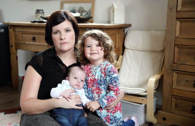 Andrea Cochrane, who was punched in the face during a car-jacking in Belfast last weekend, at home at Hillsborough with her children Daniel and Megan. US1443-540cd  Picture: Cliff Donaldson